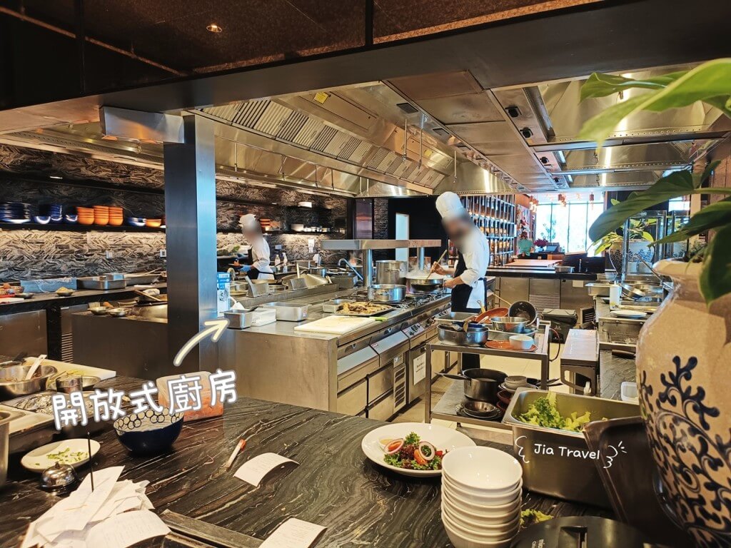 Open kitchen at Market Cafe by Khao, showcasing chefs preparing dishes a la minute.
