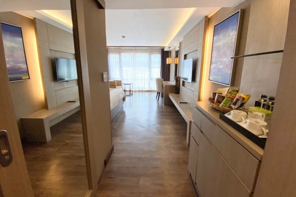 Arte Hotel Bangkok room entrance view with bathroom on left and mini bar on right