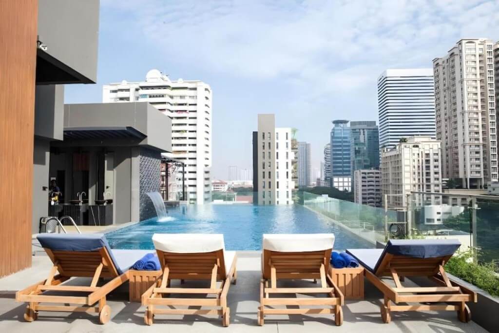 Arte Hotel Bangkok rooftop pool with sun loungers and city view