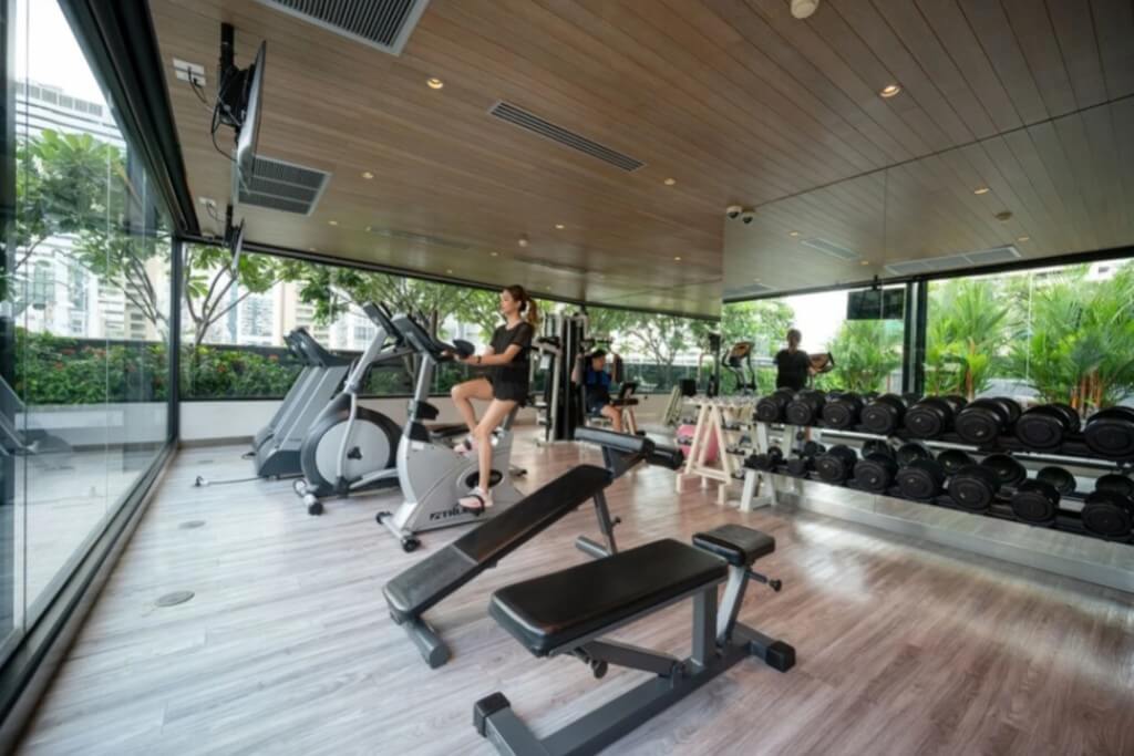 Maitria Hotel Sukhumvit 18 gym with modern fitness equipment and large windows