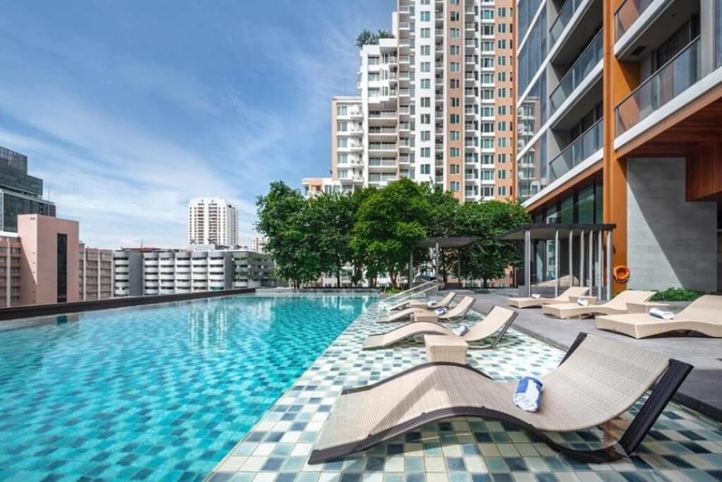 Oakwood Suites Bangkok rooftop pool with sun loungers for relaxing