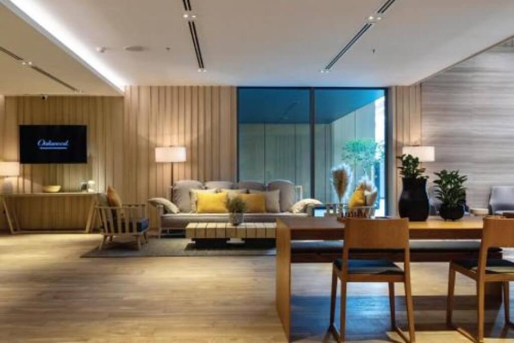 Oakwood Suites Bangkok lobby lounge area with warm wooden furniture and relaxing atmosphere