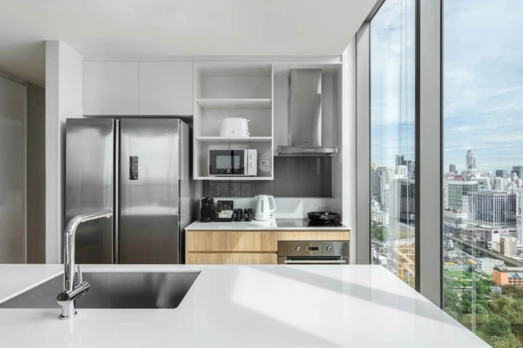Oakwood Suites Bangkok kitchen with fridge, oven, microwave and hob