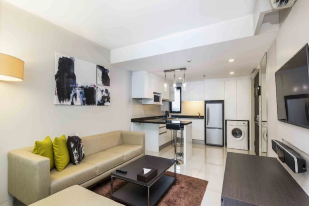 Maitria Hotel Sukhumvit 18 room with small living room area and comfortable seating