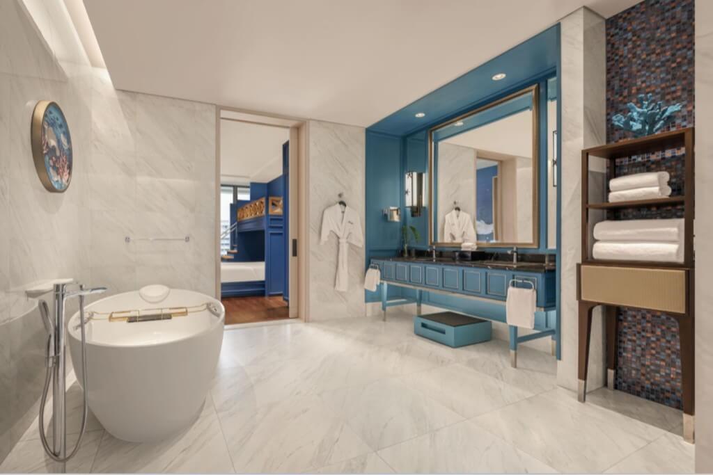 Ocean themed kids bathroom with bathtub and double sink at Sindhorn Kempinski Hotel Bangkok