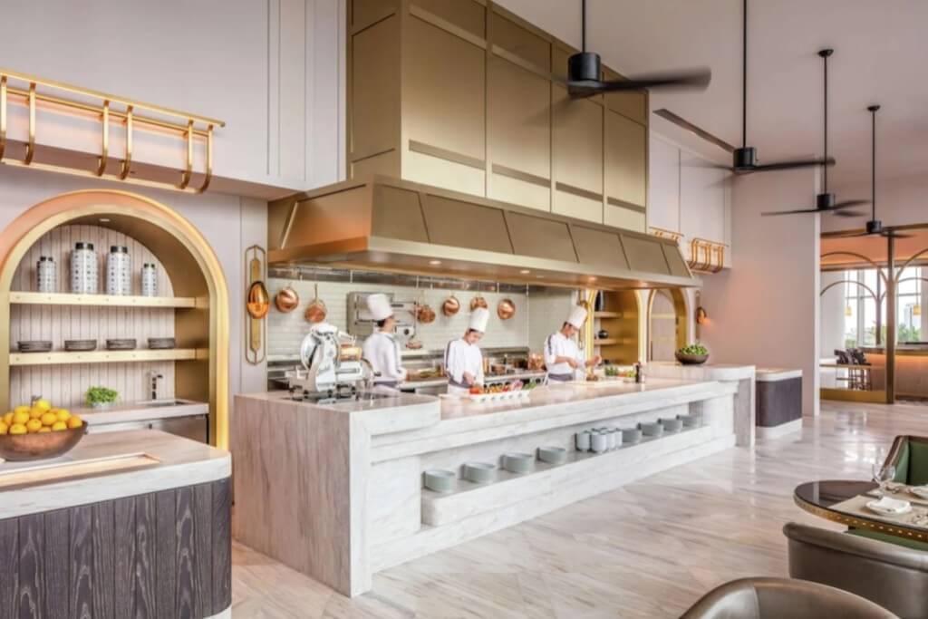 Open kitchen breakfast buffet with chef preparing fresh dishes at Waldorf Astoria Bangkok