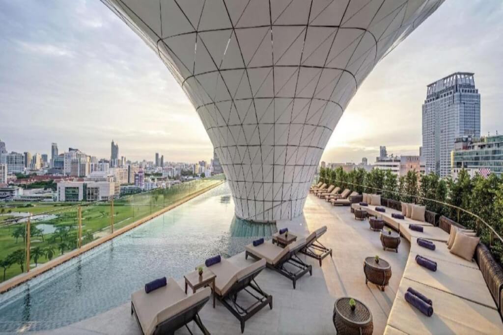 Rooftop infinity pool with open city view during daytime at Waldorf Astoria Bangkok