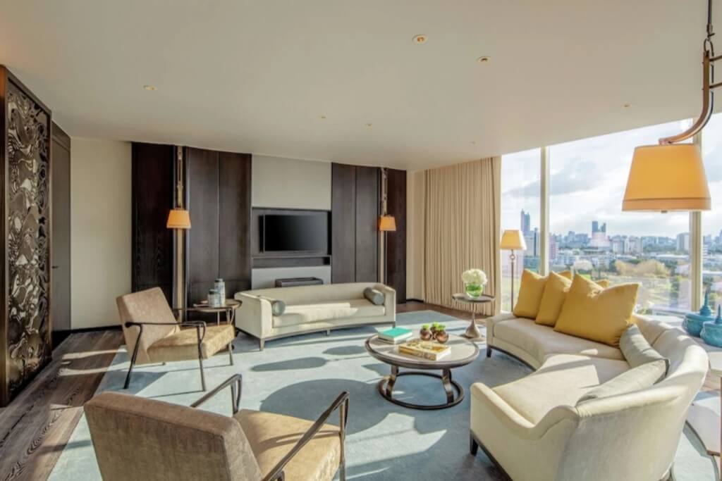 Two bedroom suite living room with large floor-to-ceiling windows and great city view at Waldorf Astoria Bangkok
