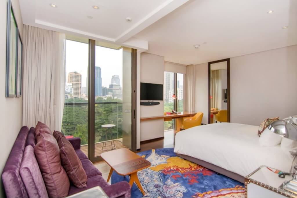 Hotel Indigo Bangkok Wireless Road guest room with small balcony overlooking Wireless Road