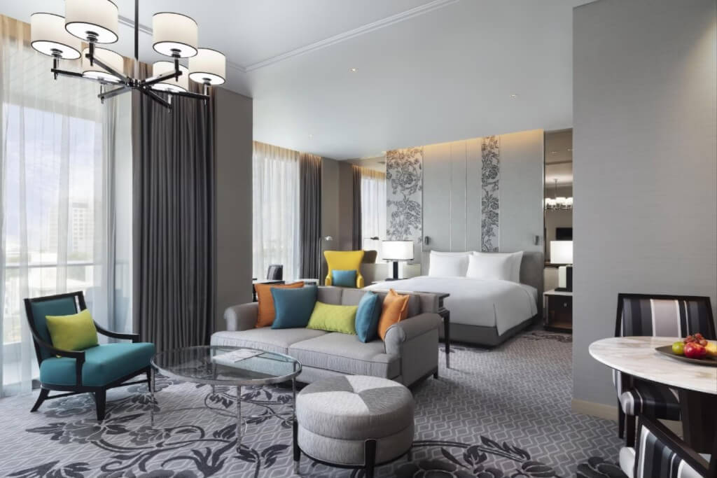 Deluxe room with sofa and dining area at Sindhorn Kempinski Hotel Bangkok
