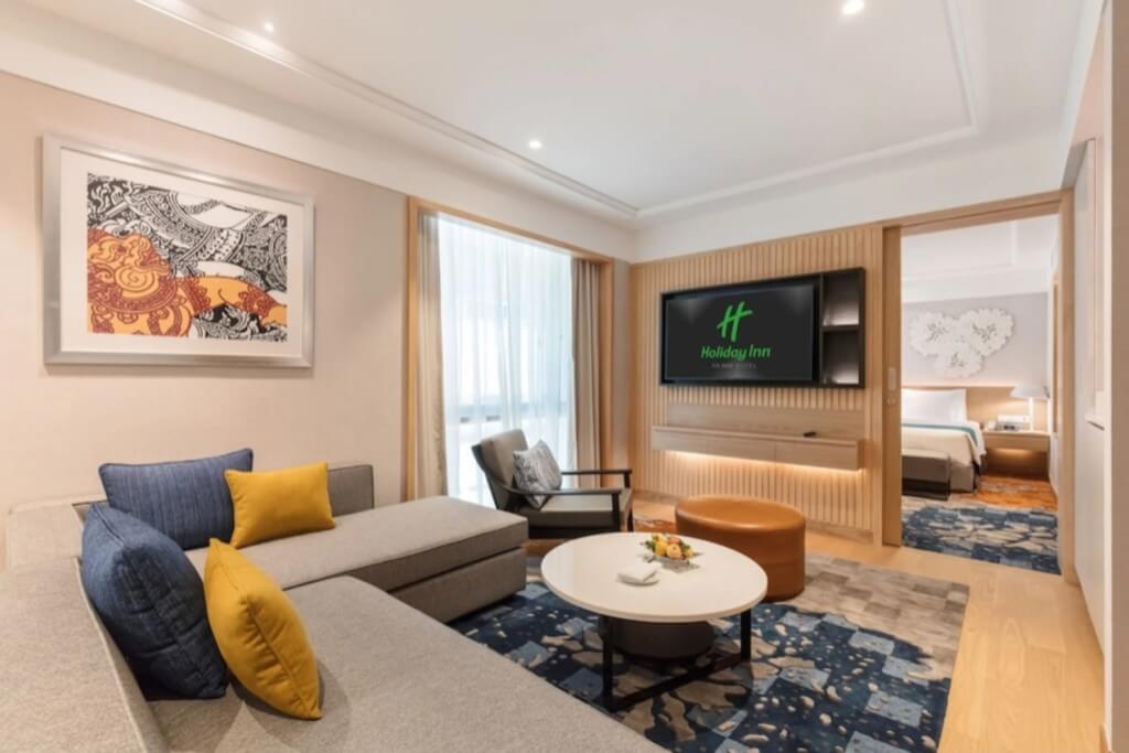 Holiday Inn Bangkok suite separate living room spacious layout with sofa and TV