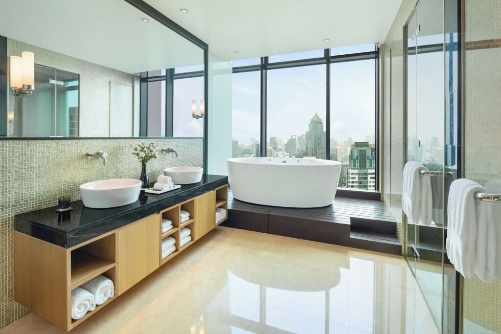 large luxury bathroom with bathtub and separate shower at The St. Regis Bangkok suite