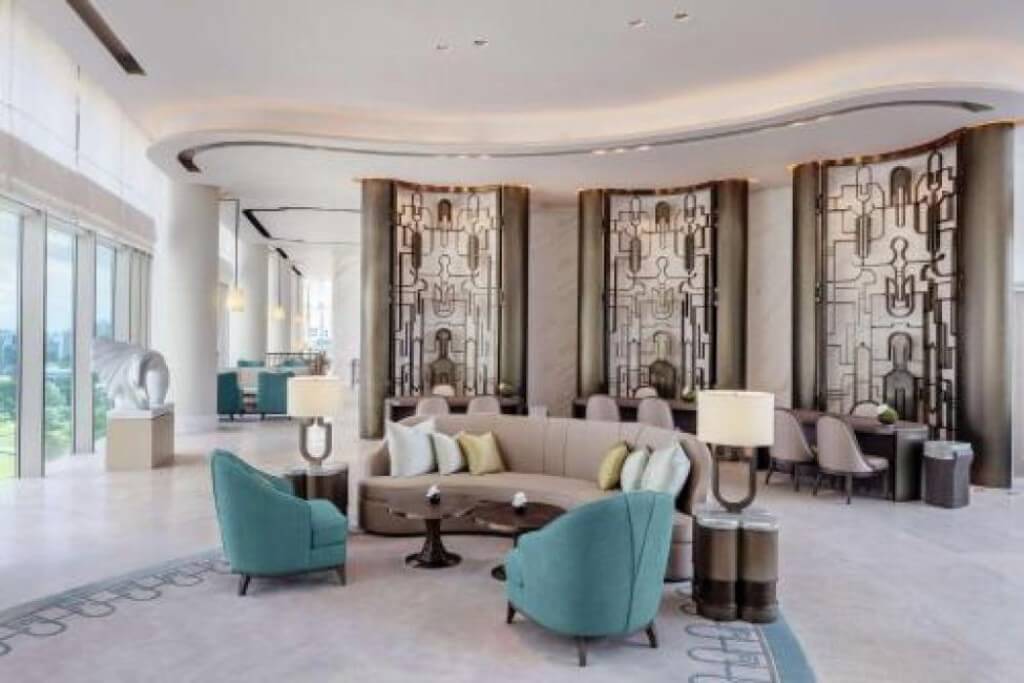 Spacious Waldorf Astoria Bangkok lobby with large floor-to-ceiling windows and natural light