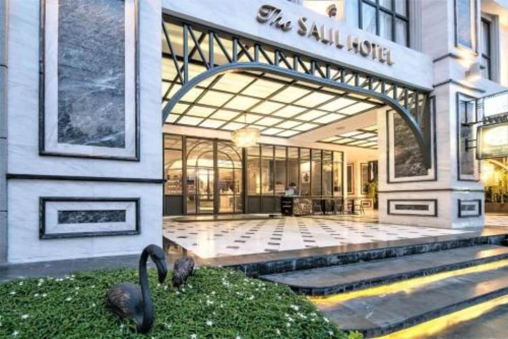 The Salil Hotel Sukhumvit 57 main entrance with vintage arched door and dark wood frame
