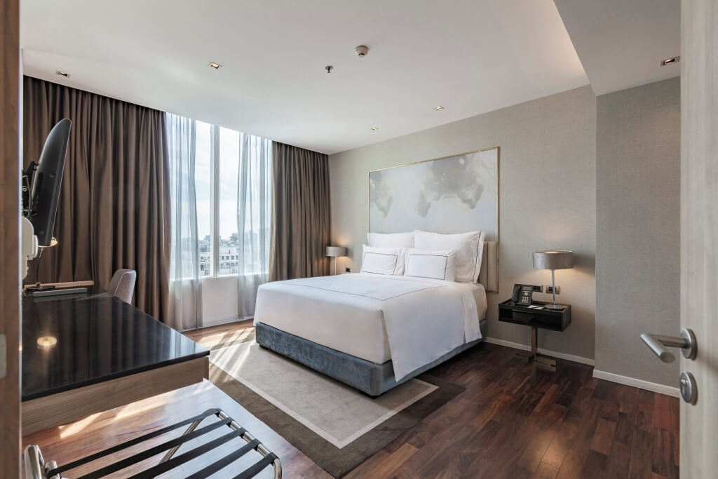 Spacious bedroom with luggage rack at MUU Bangkok Hotel suite