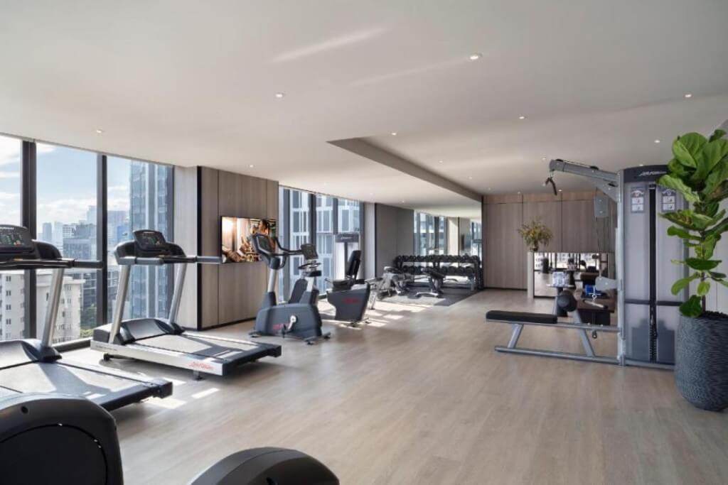 Ascott Thonglor Bangkok spacious gym with large windows and many equipment