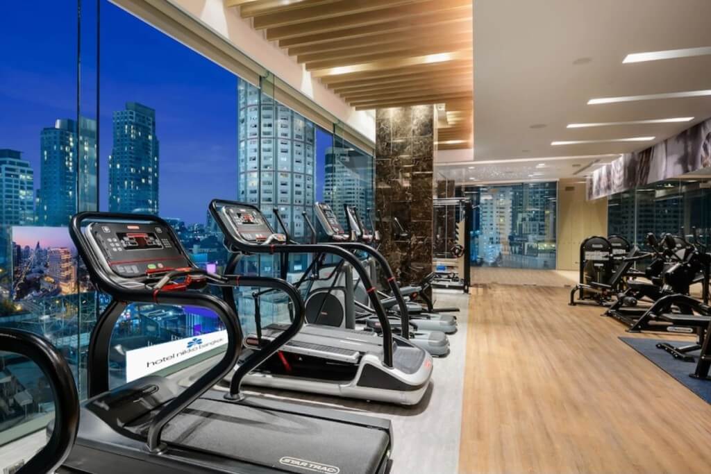 High floor gym with large windows and Bangkok night view at Hotel Nikko Bangkok