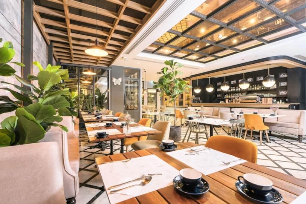 The Salil Hotel Sukhumvit 57 breakfast seating area with lush green plants and natural lighting