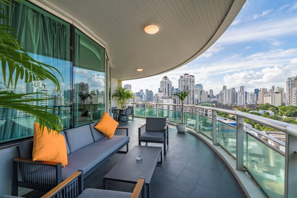 Rooftop terrace seating area at MUU Bangkok Hotel with night view