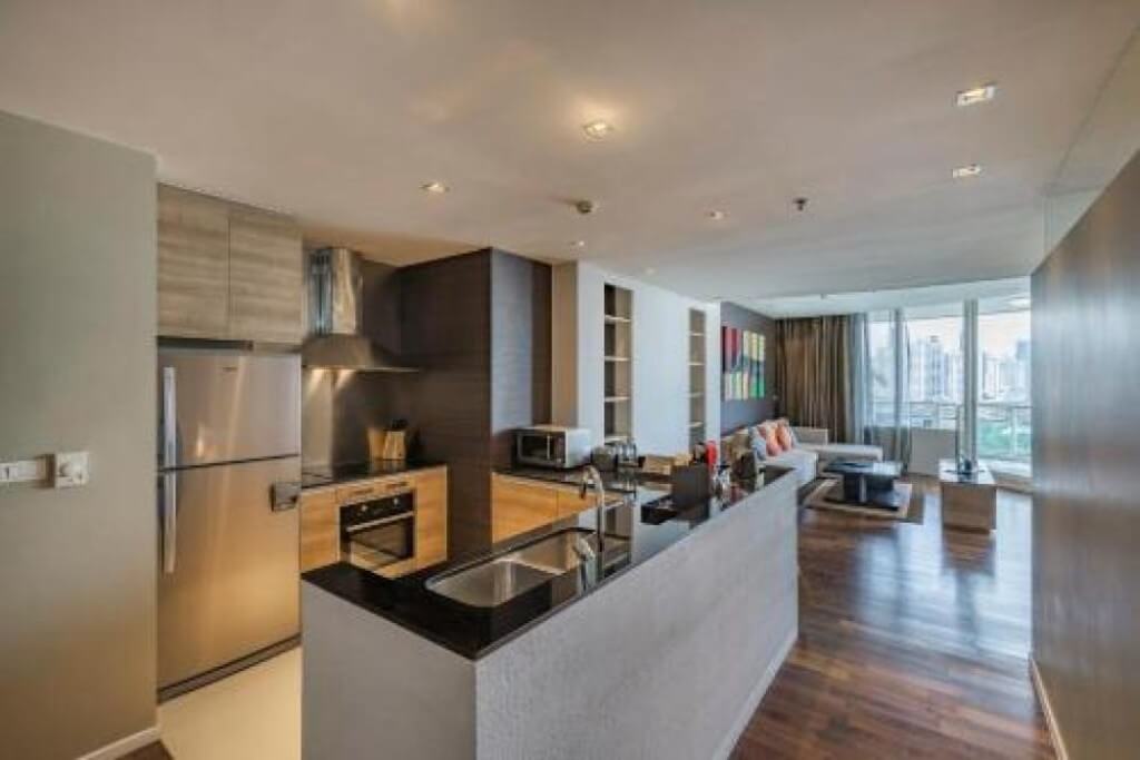 Full island kitchen with refrigerator and oven at MUU Bangkok Hotel suite