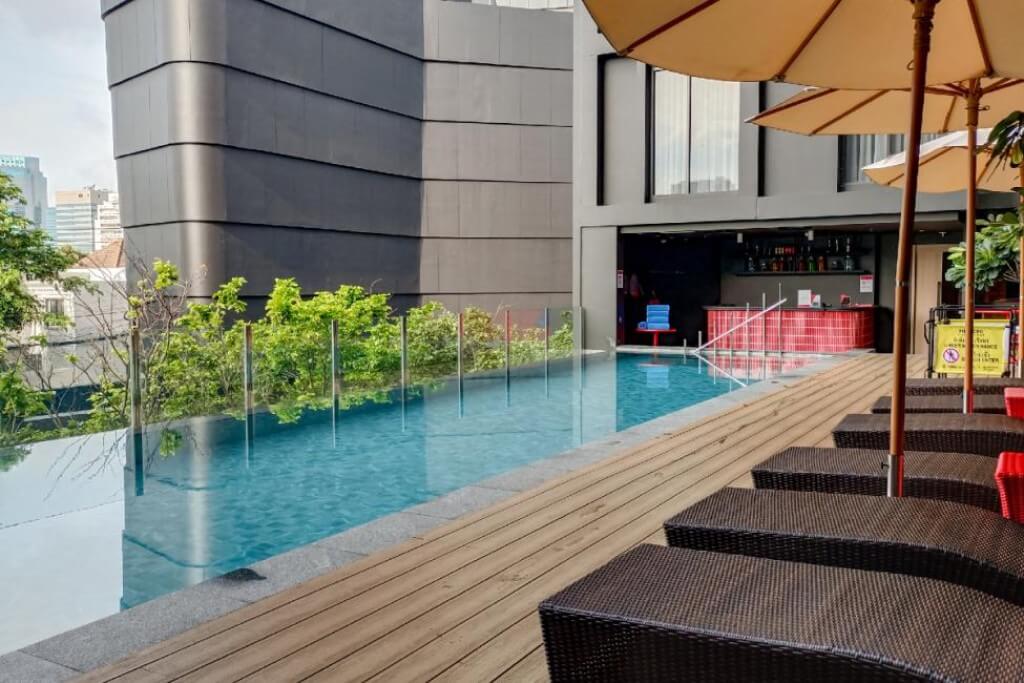 swimming pool surrounded by building with natural shade at Oakwood Studios Sukhumvit Bangkok