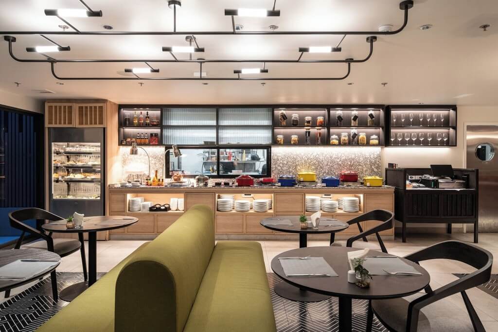 breakfast buffet with wooden tone and colorful cookware at Oakwood Studios Sukhumvit Bangkok