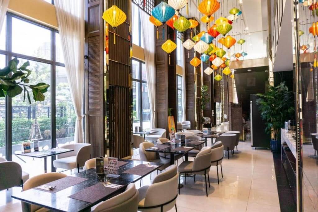 Bright breakfast seating area with large windows at Ramada Plaza by Wyndham Bangkok Sukhumvit 48