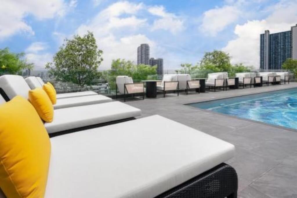 Swimming pool with plenty of lounge chairs at Ramada Plaza Bangkok