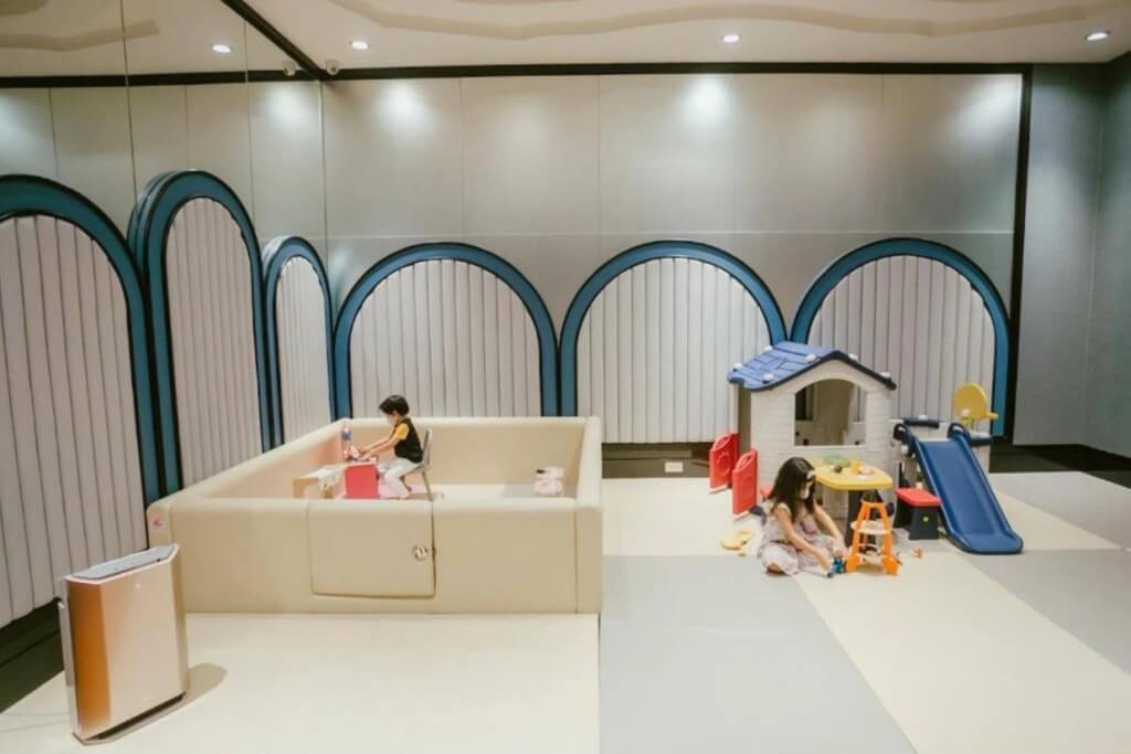 Kids play area with slide pretend kitchen toys and books at Grande Centre Point Sukhumvit 55