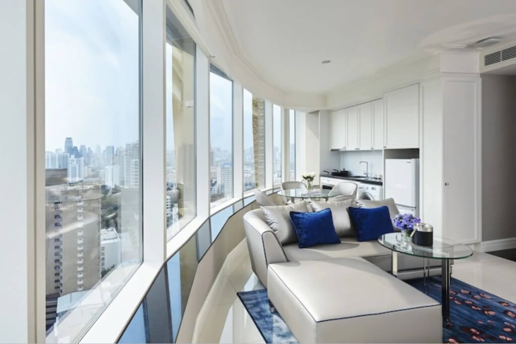 Corner suite with living room dining area and curved window at Grande Centre Point Sukhumvit 55