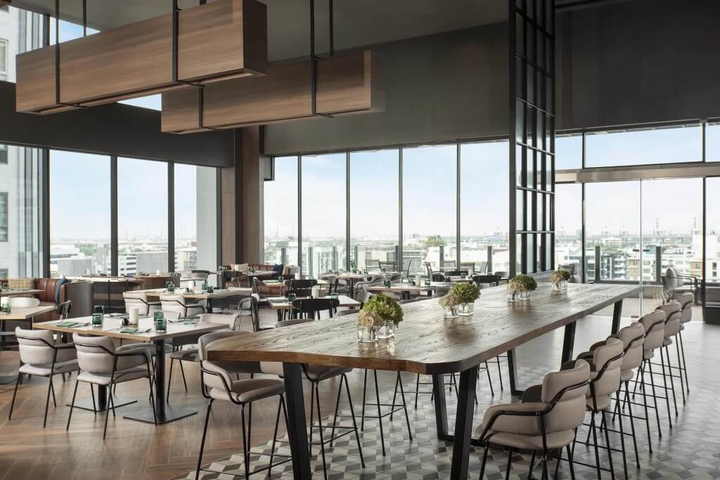 Avani Sukhumvit Bangkok bright breakfast seating with floor-to-ceiling windows and spacious tables