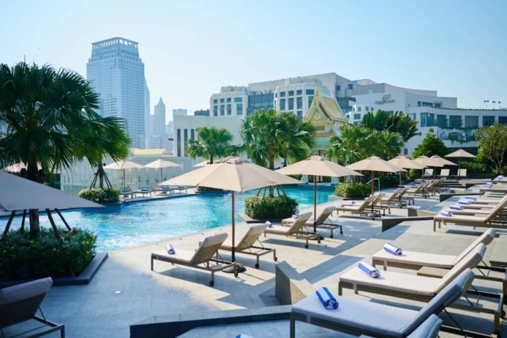 Chatrium Grand Bangkok pool lounge chairs and city view