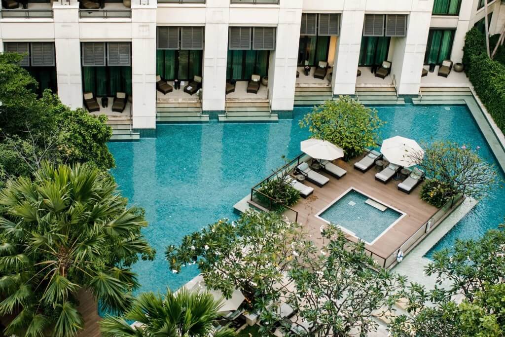 Siam Kempinski Hotel Bangkok swimming pool curved design integrated with garden landscape