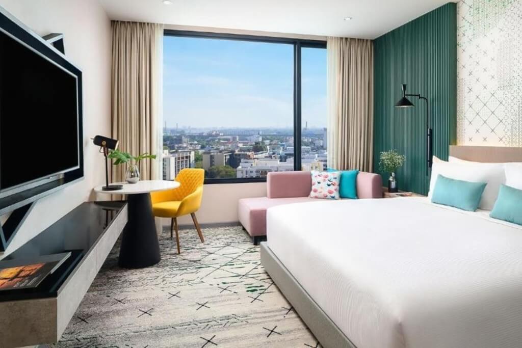 Avani Sukhumvit Bangkok double room with pink chaise lounge and yellow accent chair by the window