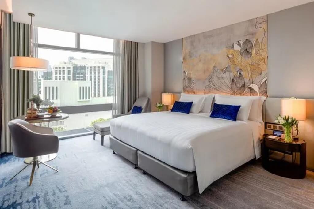 Chatrium Grand Bangkok deluxe room bed and large window