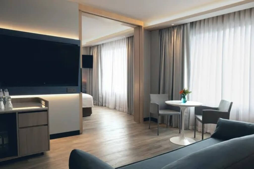 Novotel Bangkok Siam Square suite living room with comfortable seating area and city view