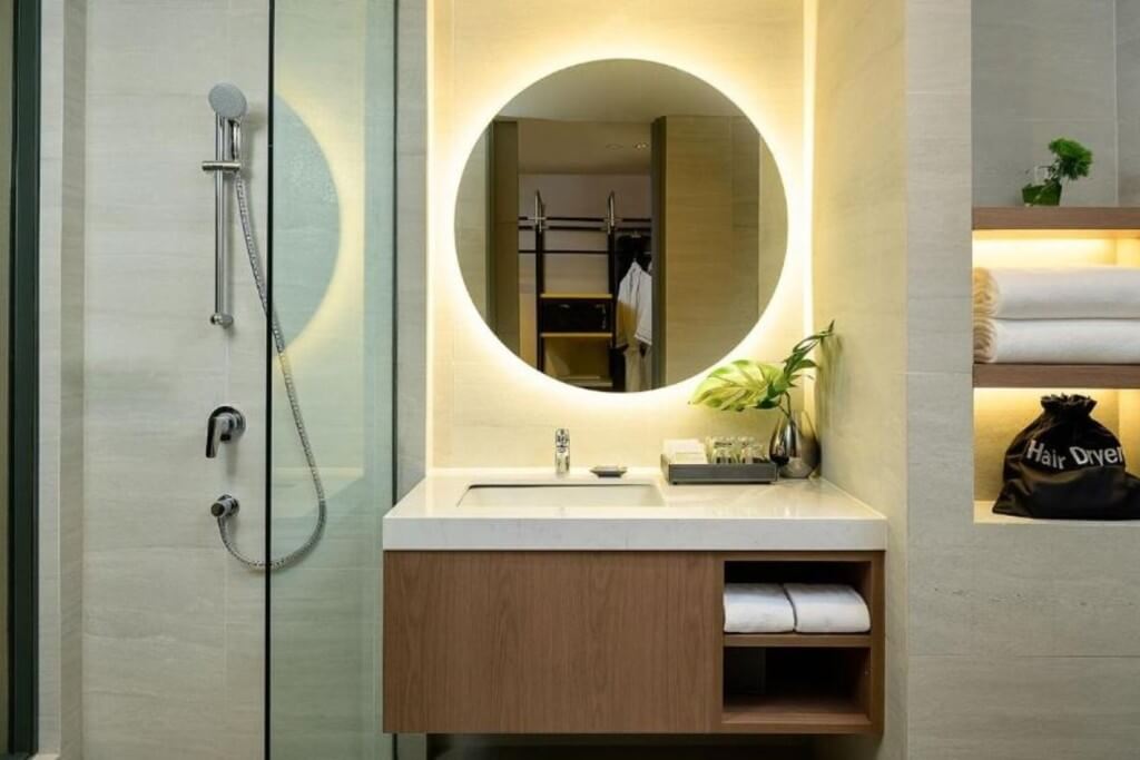 Avani Sukhumvit Bangkok bathroom with warm white tiles and wooden vanity