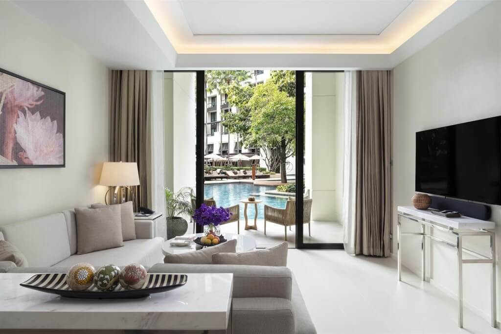 Siam Kempinski Hotel Bangkok duplex Kawana room level one living room with balcony and two lounge chairs