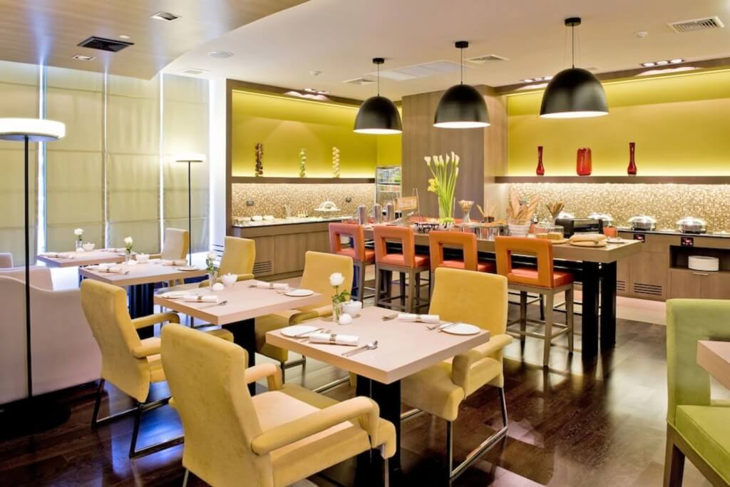 Novotel Bangkok Siam Square breakfast seating with red yellow green tables and chairs