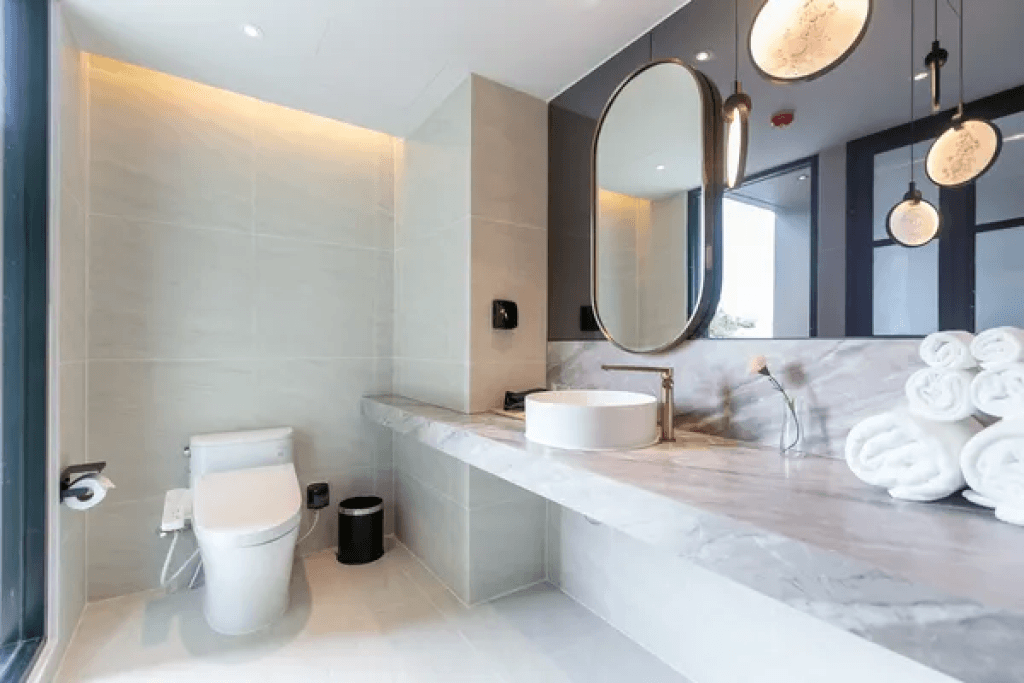 Bathroom sink and toilet in double suite at Sacha Thonglor