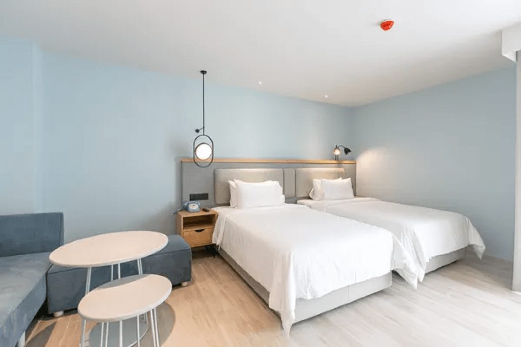 Twin suite with two single beds and L shaped sofa at Sacha Thonglor